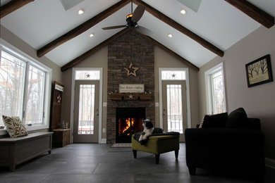 Design ideas for a mid-sized traditional open concept family room in DC Metro with grey walls, porcelain floors, a standard fireplace, a stone fireplace surround and no tv.