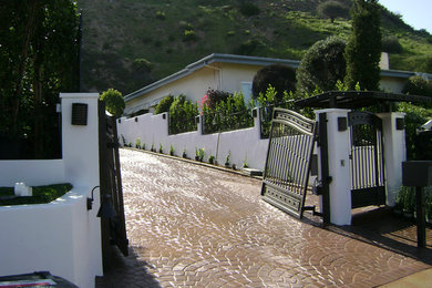 Photo of a large mediterranean full sun brick driveway in Los Angeles.