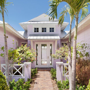 Idéer för ett mycket stort exotiskt rosa hus, med två våningar, valmat tak och tak i metall