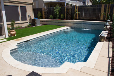 Mid-sized traditional backyard custom-shaped pool in Sacramento with a water feature and concrete pavers.