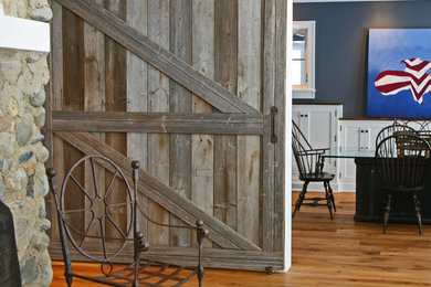 Kitchen/dining room combo - large transitional light wood floor kitchen/dining room combo idea in Milwaukee with gray walls, a standard fireplace and a stone fireplace