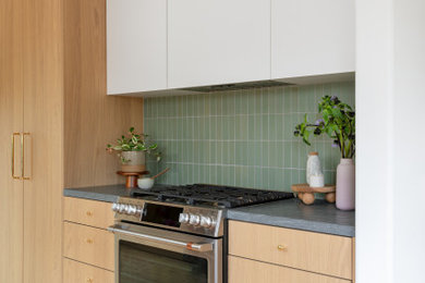Enclosed kitchen - small scandinavian galley light wood floor and brown floor enclosed kitchen idea in San Francisco with an undermount sink, flat-panel cabinets, light wood cabinets, granite countertops, green backsplash, ceramic backsplash, stainless steel appliances, no island and gray countertops