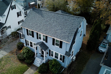 Imagen de fachada de casa azul y gris de tamaño medio de dos plantas con revestimiento de madera, tejado a dos aguas, tejado de teja de madera y teja
