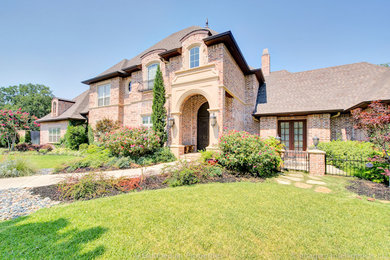 Example of a huge classic two-story brick exterior home design in Dallas