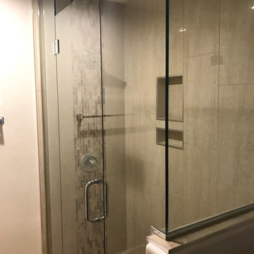 Polished porcelain tile shower with vertical deco band
