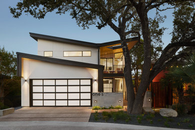 Mid-sized minimalist white four-story stucco house exterior photo in Austin with a butterfly roof, a metal roof and a black roof