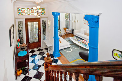 Eclectic multicolored floor entryway photo in New York with white walls and a glass front door
