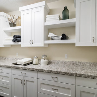 ソルトレイクシティの中サイズのコンテンポラリースタイルのおしゃれな洗濯室 (シェーカースタイル扉のキャビネット、白いキャビネット、御影石カウンター、ベージュの壁、クッションフロア、左右配置の洗濯機・乾燥機) の写真