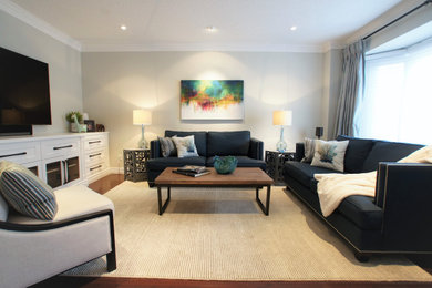 Family room - large transitional enclosed dark wood floor and brown floor family room idea in Toronto with gray walls, no fireplace and a media wall