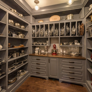 Réalisation d'une arrière-cuisine tradition en U avec un placard avec porte à panneau surélevé, des portes de placard grises, un plan de travail en bois, une crédence blanche, un sol en bois brun, aucun îlot, un sol marron et un plan de travail marron.