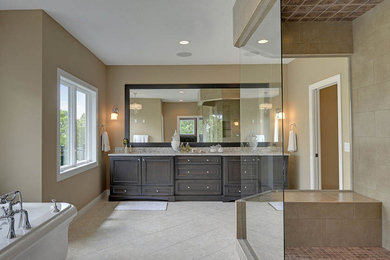 Photo of an expansive traditional master bathroom in Other with beaded inset cabinets, medium wood cabinets, a freestanding tub, a corner shower, stone tile, beige walls, porcelain floors, an undermount sink, granite benchtops and beige tile.