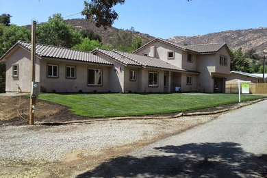 Large traditional brown two-story stucco exterior home idea in San Diego