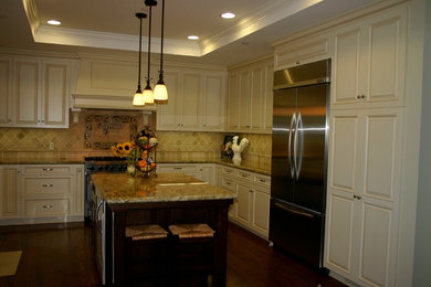 Example of an arts and crafts dark wood floor kitchen design in San Francisco with an undermount sink, raised-panel cabinets, white cabinets, granite countertops, multicolored backsplash, stone tile backsplash, stainless steel appliances and an island