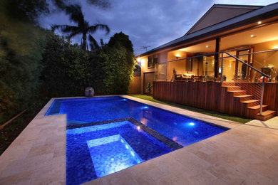 Mid-sized contemporary backyard custom-shaped lap pool in Melbourne with natural stone pavers and a hot tub.