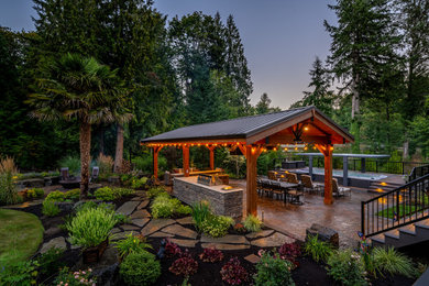 Diseño de jardín de estilo americano grande en patio trasero con brasero y adoquines de piedra natural