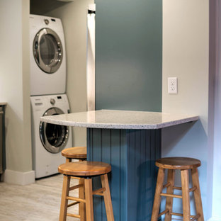 Kleine Moderne Küche in L-Form mit Vorratsschrank, Landhausspüle, Schrankfronten im Shaker-Stil, blauen Schränken, Arbeitsplatte aus Recyclingglas, Küchenrückwand in Weiß, Rückwand aus Keramikfliesen, Küchengeräten aus Edelstahl, Keramikboden, Kücheninsel und beigem Boden in Boston