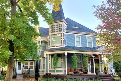 Ornate blue two-story house exterior photo in Minneapolis with a shingle roof and a gray roof