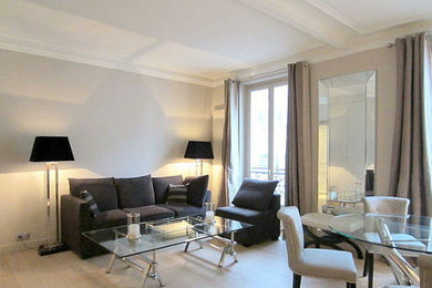 This is an example of a medium sized contemporary games room in Paris with grey walls, light hardwood flooring, a wall mounted tv and grey floors.