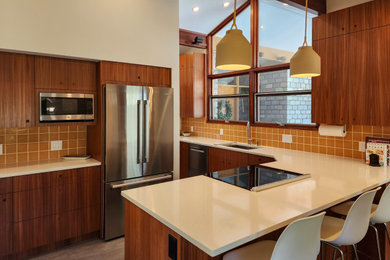Kitchen - mid-sized 1950s porcelain tile, gray floor and exposed beam kitchen idea in Boston with an undermount sink, medium tone wood cabinets, quartz countertops, orange backsplash, ceramic backsplash, stainless steel appliances, a peninsula and white countertops
