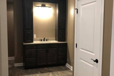 Mid-sized transitional master beige tile porcelain tile and multicolored floor doorless shower photo in Indianapolis with raised-panel cabinets, dark wood cabinets, beige walls, an undermount sink, quartz countertops and white countertops