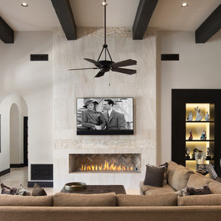 Modelo de salón mediterráneo con paredes blancas, chimenea lineal, marco de chimenea de baldosas y/o azulejos, televisor colgado en la pared y suelo beige