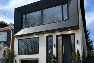 Large minimalist multicolored two-story mixed siding house exterior photo in Toronto with a shed roof and a black roof