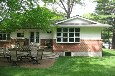 Imagen de fachada de casa blanca clásica de tamaño medio de una planta con revestimientos combinados, tejado a cuatro aguas y tejado de teja de madera