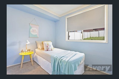 Modelo de dormitorio moderno de tamaño medio con paredes azules y moqueta