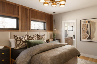 Example of a trendy master light wood floor, beige floor and wood wall bedroom design in Denver