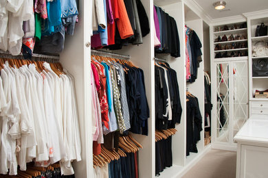 Inspiration for a large timeless women's carpeted walk-in closet remodel in Houston with recessed-panel cabinets and white cabinets
