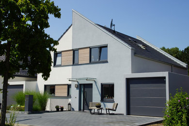 Mittelgroßes, Einstöckiges Modernes Einfamilienhaus mit Putzfassade, grauer Fassadenfarbe, Satteldach und grauem Dach in Düsseldorf