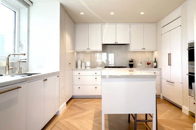 Mid-sized trendy u-shaped light wood floor and brown floor kitchen pantry photo in New York with an undermount sink, flat-panel cabinets, white cabinets, quartzite countertops, gray backsplash, white appliances, an island and gray countertops