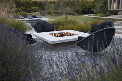 Inspiration for a large contemporary full sun and drought-tolerant backyard gravel landscaping in Los Angeles with a fire pit.
