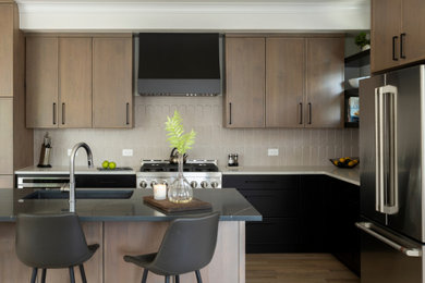 Mid-sized 1960s l-shaped laminate floor and brown floor eat-in kitchen photo in Denver with an undermount sink, shaker cabinets, beige cabinets, quartz countertops, beige backsplash, ceramic backsplash, stainless steel appliances, an island and black countertops