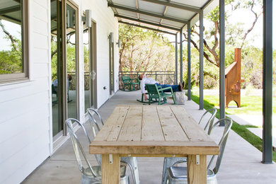 This is an example of a country verandah in Austin with concrete slab and a roof extension.