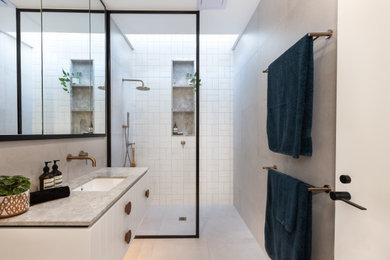 Photo of a small contemporary bathroom in Melbourne with recessed-panel cabinets, white cabinets, an open shower, a wall-mount toilet, multi-coloured tile, ceramic tile, grey walls, porcelain floors, an undermount sink, marble benchtops, grey floor, an open shower, grey benchtops, a niche, a single vanity and a floating vanity.