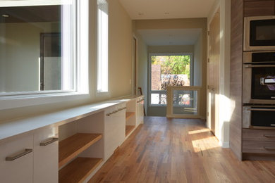 Inspiration for a modern medium tone wood floor hallway remodel in Minneapolis with beige walls