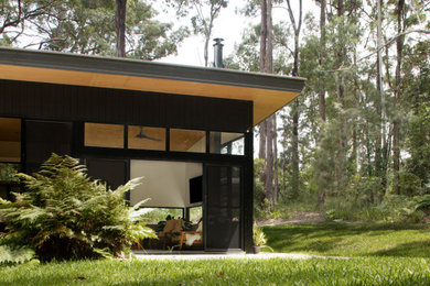 Design ideas for a small midcentury black house exterior in Sunshine Coast.
