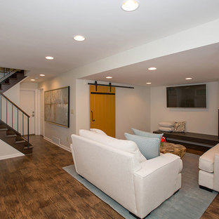 Medium sized contemporary fully buried basement in Cincinnati with beige walls, medium hardwood flooring, a corner fireplace, a tiled fireplace surround and brown floors.