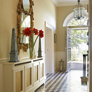 Esempio di un ingresso o corridoio tradizionale con pareti gialle e pavimento multicolore