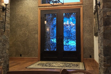 Inspiration for a huge rustic medium tone wood floor and brown floor entryway remodel in Other with a brown front door