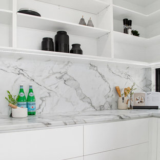 Design ideas for a mid-sized modern l-shaped kitchen pantry in Gold Coast - Tweed with white splashback, marble splashback and white benchtop.