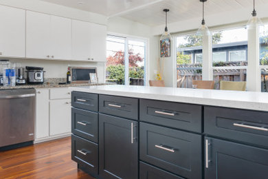 Example of a mid-sized transitional u-shaped dark wood floor and brown floor eat-in kitchen design in San Francisco with an undermount sink, shaker cabinets, black cabinets, quartz countertops, white backsplash, stainless steel appliances, an island and white countertops
