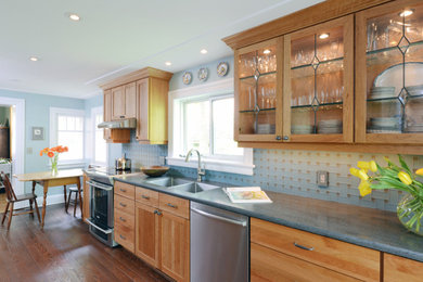Photo of a traditional galley eat-in kitchen in Ottawa with an undermount sink, medium wood cabinets, solid surface benchtops, glass tile splashback and stainless steel appliances.