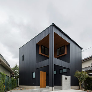 他の地域のミッドセンチュリースタイルのおしゃれな家の外観 (黒い外壁) の写真