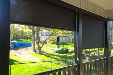 Small transitional screened-in porch idea in Toronto with decking