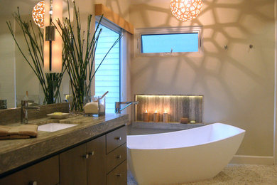 Bathroom - large transitional master beige tile and pebble tile pebble tile floor bathroom idea in Orange County with flat-panel cabinets, medium tone wood cabinets, a one-piece toilet, an undermount sink, gray walls and soapstone countertops