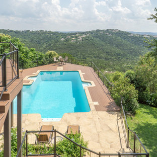 Bild på en stor funkis l-formad pool på baksidan av huset, med spabad och trädäck