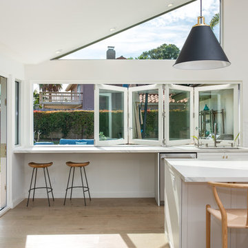 AG BiFold Patio Door & Window Pairing Connects All-White Kitchen to the Outdoors