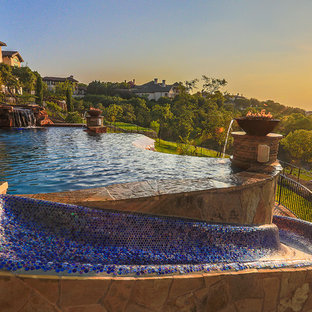 Großer Mediterraner Infinity-Pool hinter dem Haus in individueller Form mit Wasserrutsche und Natursteinplatten in Austin